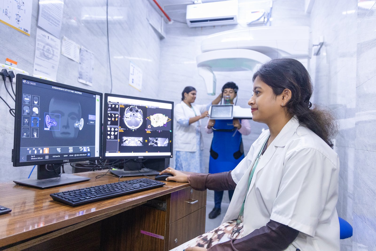 Audiologist analyzing ear scan images at a hearing implant clinic.