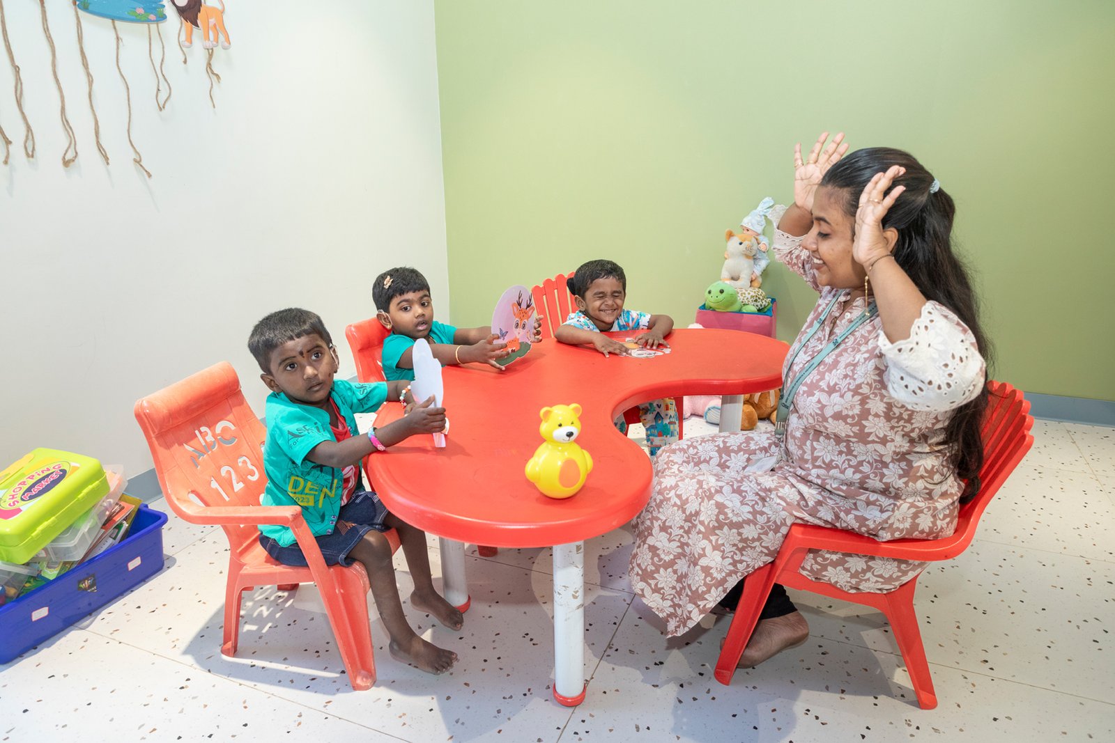 Therapist conducting a group speech therapy activity with children at a hearing implant clinic.